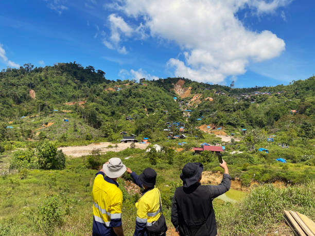 A June 2023 photo of the Rek Rinti artisanal gold mining area in Pidie Regency of Aceh province, Indonesia.  Miners are digging holes into the mountains to excavate gold bearing epithermal quartz veins.  Fragments of quartz vein are collected and processed in trommels to extract the gold and silver from the quartz.